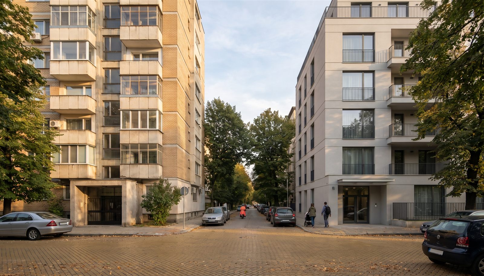 A tree-lined Sofia street where an older panel apartment block faces a new contemporary building